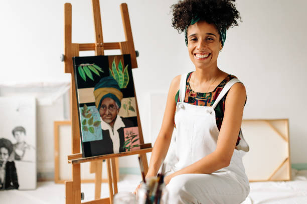 peintre insouciante souriant dans son atelier - artiste photos et images de collection