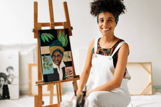 pittrice spensierata sorridente nel suo studio - art freedom paintbrush painting foto e immagini stock