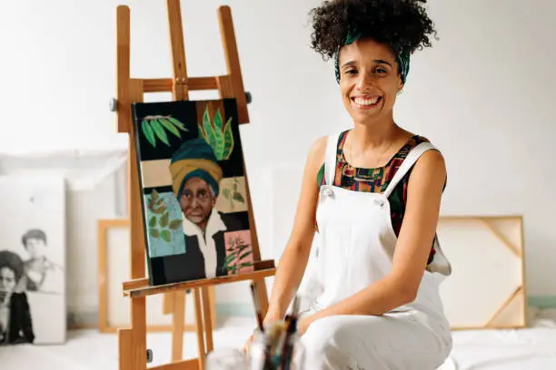 Photo of Carefree female painter smiling in her studio