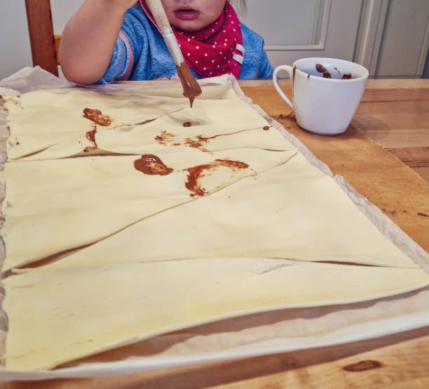 istock Small child bakes chocolate croissants 1368073595