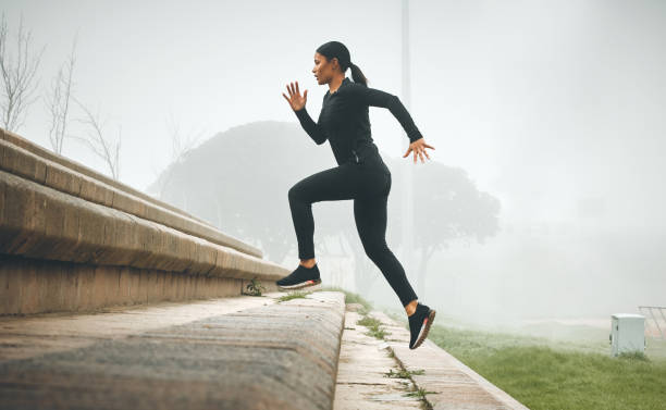 Shot of a sporty young woman running up steps outdoors Every step counts for something woman sprint stock pictures, royalty-free photos & images