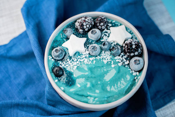 Healthy breakfast berry, banana smoothie bowl topped with Blueberries and chia seeds , blackberries coconut delicious blueberry smoothie bowl. vegan raw food. Selective focus. copy space