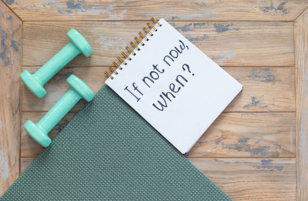 istock Dumbbells, exercise mat and notepad with motivational inscription - if not now, when 1368077011