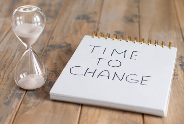 istock Hourglass and notepad with motivational inscription - Time to change. Striving for change, push for development concept 1368077152