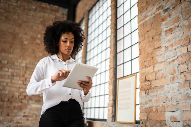 istock Young business woman using digital tablet in an office 1368082485