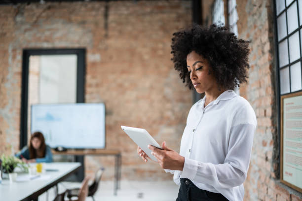 istock Young business woman using digital tablet in an office 1368082498