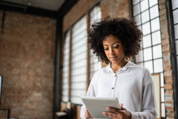 istock Young business woman using digital tablet in an office 1368082505