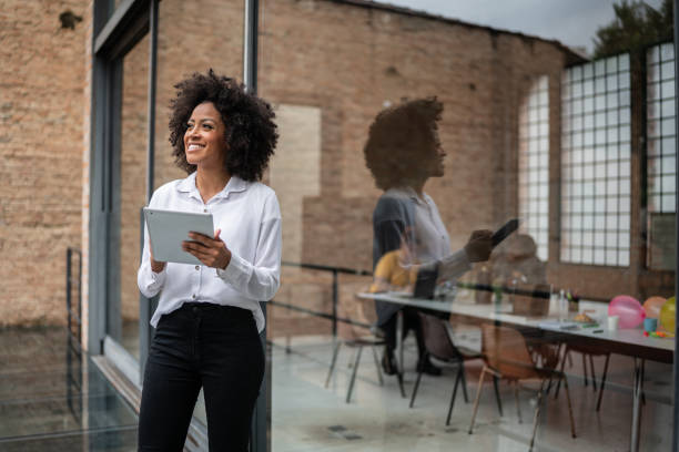 istock Businesswoman looking away and using digital tablet in an office 1368082549