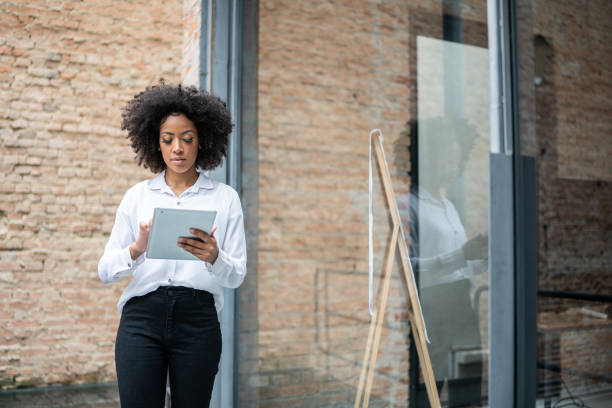 istock Young business woman using digital tablet in an office 1368082555