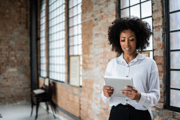 istock Young business woman using digital tablet in an office 1368082556