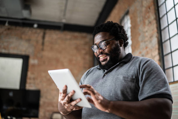 istock Business man using digital tablet in an office 1368082639