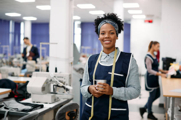 istock Happy black textile worker enjoying in her coffee break while working in a factory. 1368082647