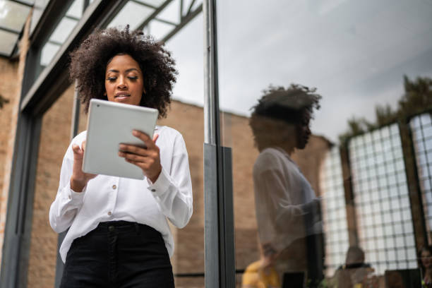 istock Young business woman using digital tablet in an office 1368082677