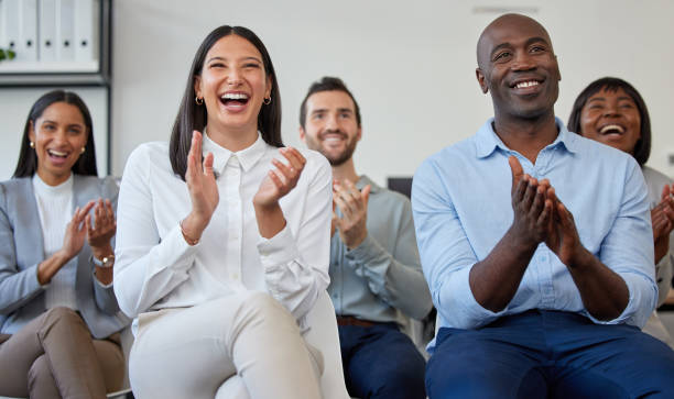 abgeschnittene aufnahme einer gruppe von geschäftsleuten, die applaudieren, während sie während einer konferenz im büro sitzen - training business seminar clapping stock-fotos und bilder