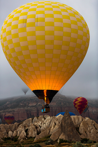 Multicolored hot air balloon on background of bright blue cloudy sky.