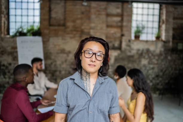 Portrait of a transgender businessman in an office Portrait of a transgender businessman in an office transgender person in office stock pictures, royalty-free photos & images