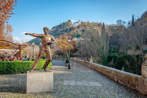 Granada, Spain - December 25 2014: The statue of Mario Maya in Albayzin, with Alhambra in the background. Maya (1937-2008) was one of the Spain's most innovative and influential flamenco dancers.