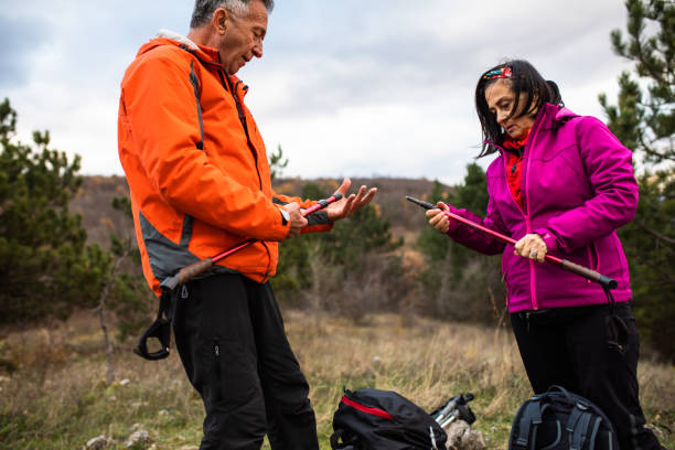 istock A senior couple adjusting their hiking poles on a hike 1368084758