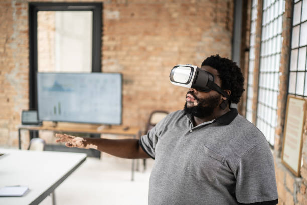 istock Mid adult man using a virtual reality glasses in the office 1368084912