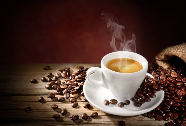 istock Steaming espresso cup and coffee beans on old wooden table, space for text. 1368085016