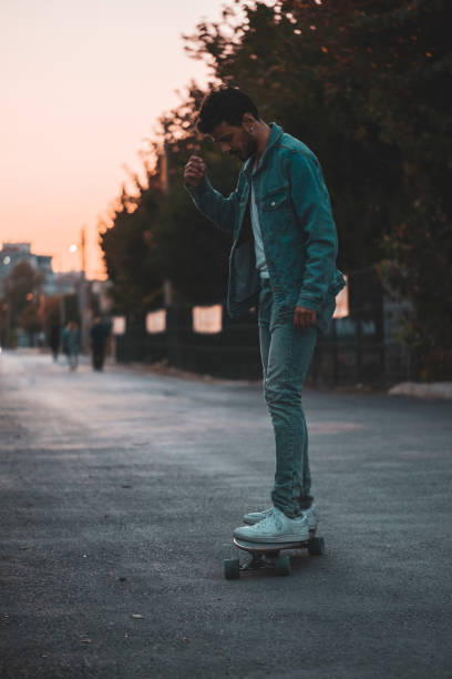 istock Middle eastern guy riding a longboard in the sunset 1368086386