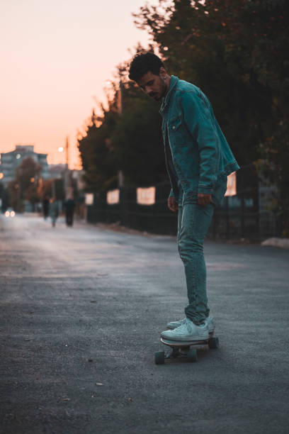istock Middle eastern guy riding a longboard in the sunset 1368086415