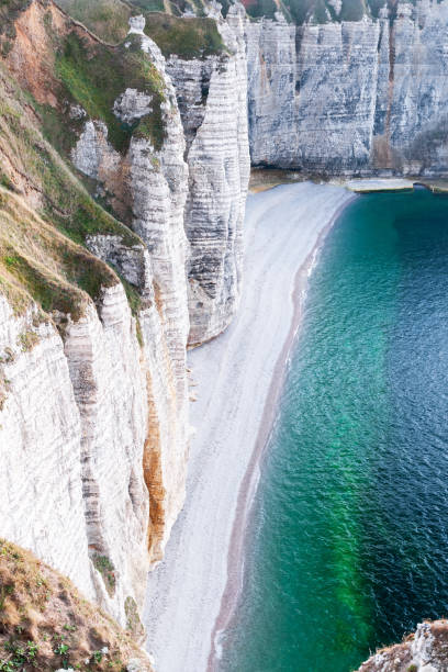 View on the alabaster coast of Normandy in Etretat View on the beach and limestone cliffs on the alabaster coast of Normandy in Etretat calcite stock pictures, royalty-free photos & images