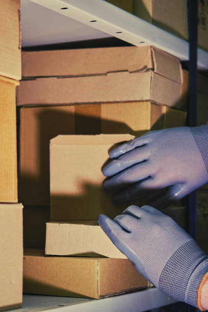istock A man in gloves steals goods from a box in a warehouse. Problems with theft and security in the office 1368088576