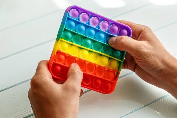 istock a man's hand presses on a colored rainbow silicone anti-stress toy pop it.Relaxation multicolored sensory pop it toy.New sensory antistress toy for children and adult. 1368088711