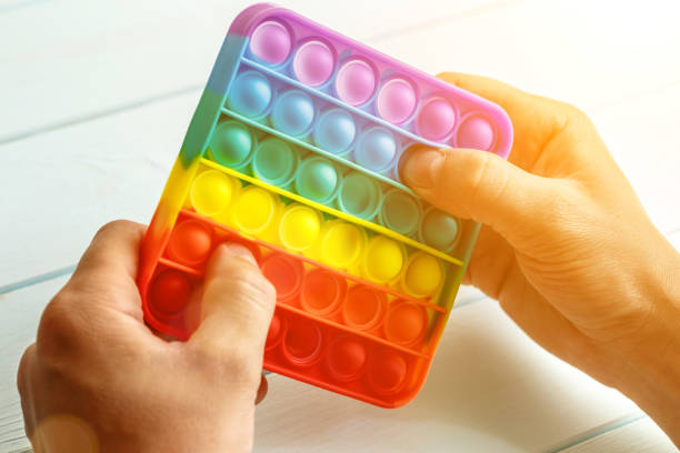 istock a man's hand presses on a colored rainbow silicone anti-stress toy pop it.Relaxation multicolored sensory pop it toy.New sensory antistress toy for children and adult. 1368088718