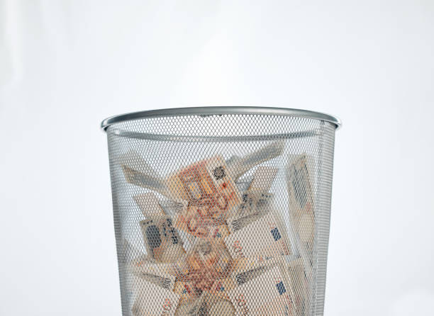 istock Studio shot of a trashcan filled with banknotes against a white background 1368090938