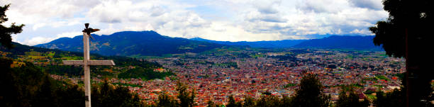 Panorama of mountains and town of Quetzaltenango with cross at top of lookout in Guatemala. stock photo