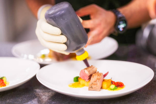 istock Chef preparing a dish with filet polenta zucchini and tomato 1368091216