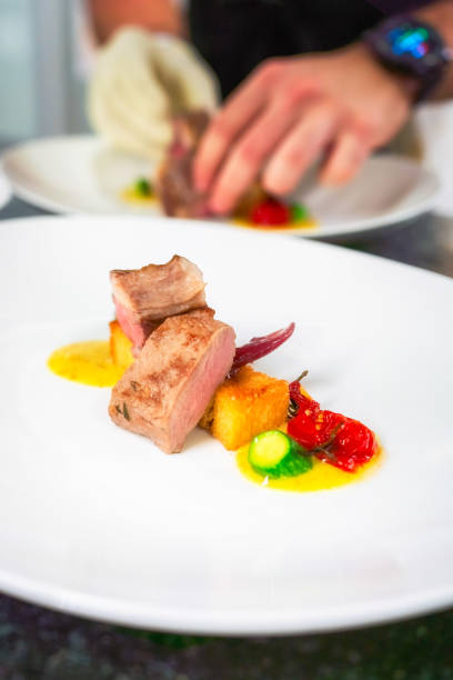 istock Chef preparing a dish with filet polenta zucchini and tomato 1368091241
