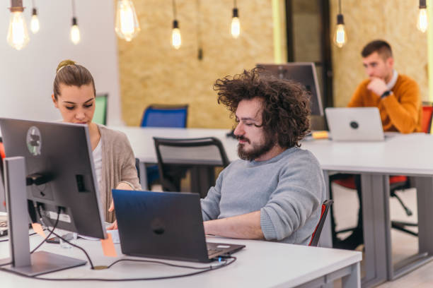 istock Two colleagues working on a project in modern startup offices. Guy with afro haircut and a female blonde employee working at the office. 1368091354