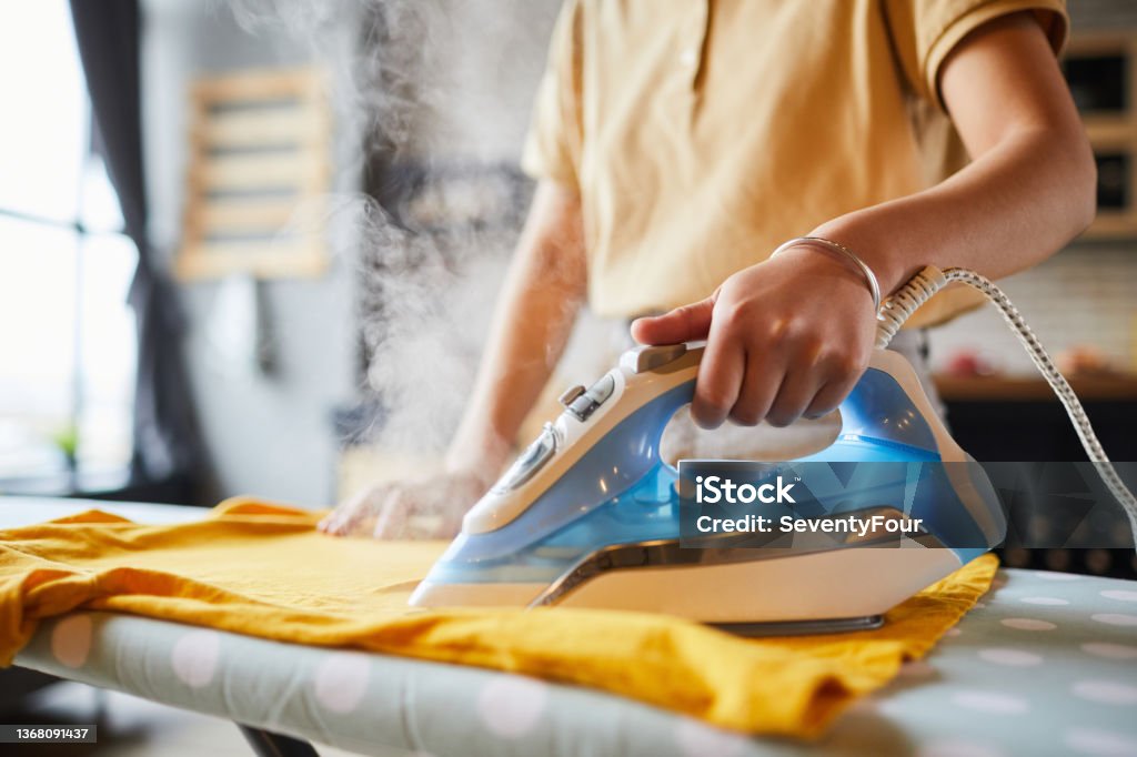 Young Woman Ironing Close Up Close up of unrecognizable young woman ironing clothes at home, simple lifestyle and household chores concept, copy space Iron - Appliance Stock Photo