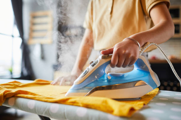 young woman ironing close up - shirt lifestyles close up cheerful imagens e fotografias de stock