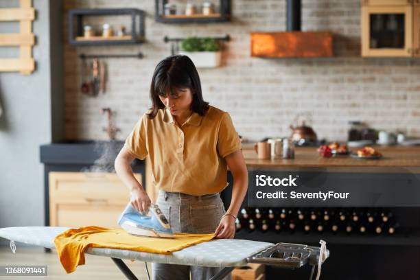 Asian Young Woman Ironing Clothes Stock Photo - Download Image Now - Iron - Appliance, Ironing Board, Women
