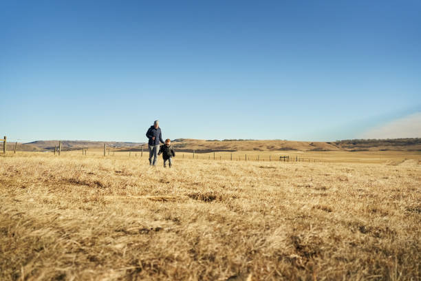 istock Mother and her son running in a dry grass field 1368091501