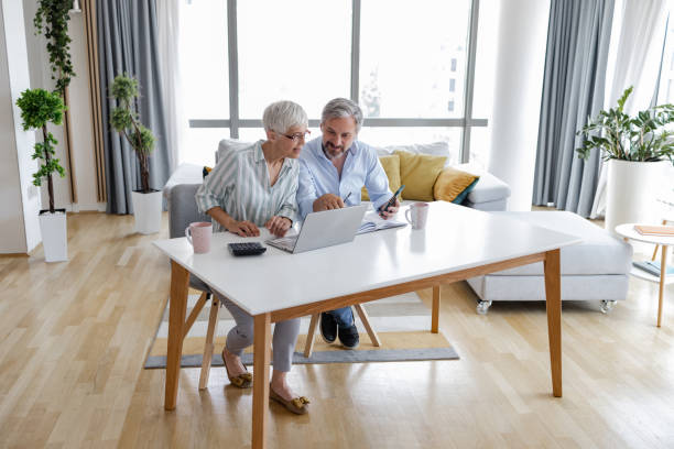istock Mature couple at home using laptop together 1368092183