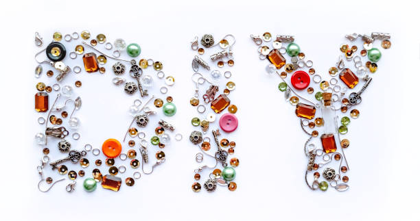 Diy lettering collected from handmade tools such as buttons, ear wires, locks, sequins, pendants on a white background. Craft and hobby concept. Banner format.