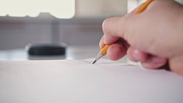istock Caucasian Male Procrastinating Drawing Abstract Shapes in Square Ruled Notebook with Mechanical Pencil during Boring Meeting 1368093878