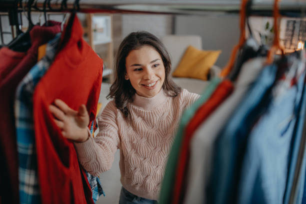 joven mujer elegir la ropa - vestimenta fotografías e imágenes de stock