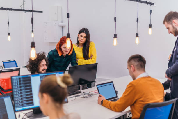 istock Group of multi-ethnic colleagues working on desktop computers and sharing their ideas in a modern office space 1368098253
