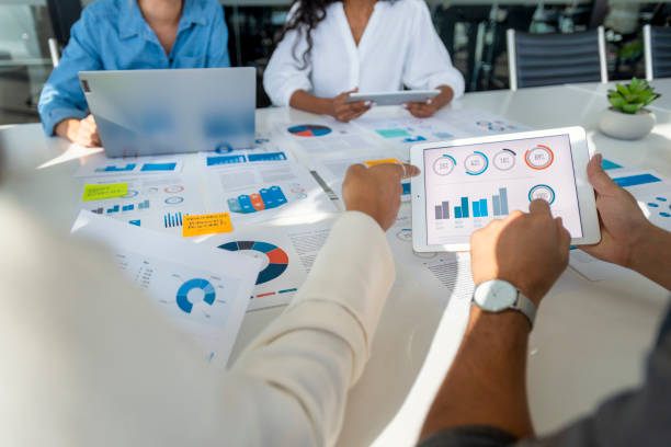 istock Group of people meeting with technology and paperwork. 1368098458
