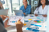 Group of people meeting with technology and paperwork