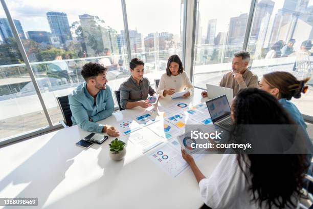 Multi Racial Group Of People Working With Paperwork On A Board Room Table At A Business Presentation Or Seminar Stock Photo - Download Image Now