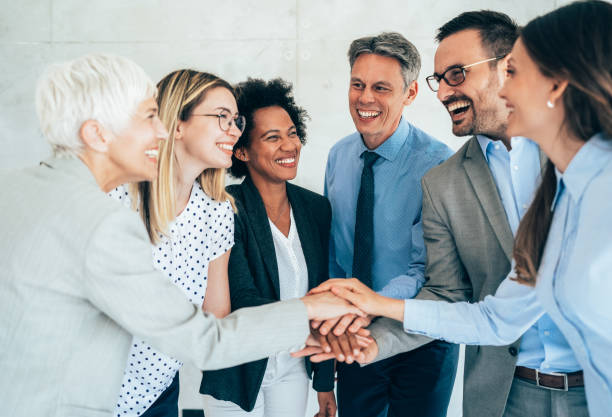 Teamwork Photo of international business team showing unity with putting their hands together on top of each other. Concept of teamwork mixed age range stock pictures, royalty-free photos & images