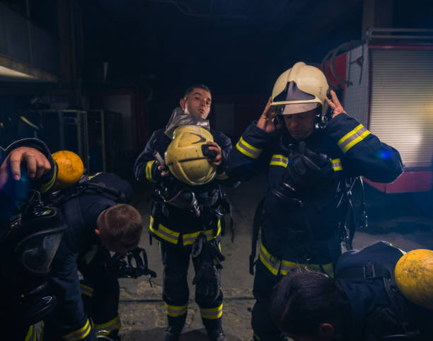 istock Group of firefighters standing inside the fire brigade wearing helmet and protective uniform 1368102395
