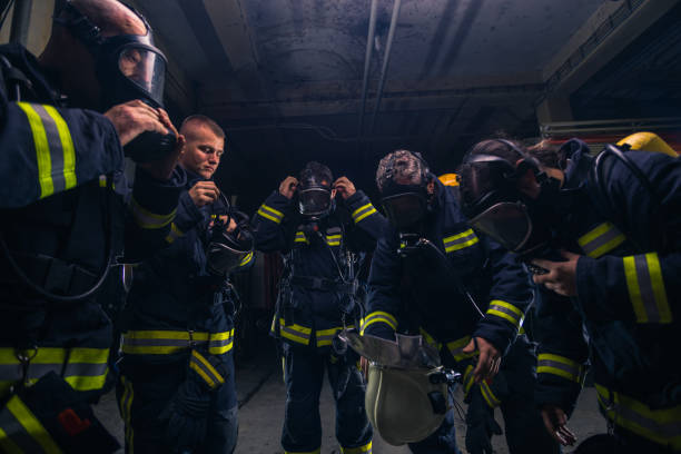 istock Group of firefighters standing inside the fire brigade wearing helmet and protective uniform 1368102398